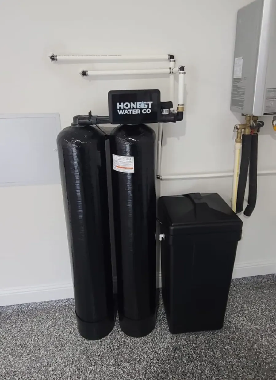Twin-tank whole-house water softener installed in a Cumming GA basement utility room