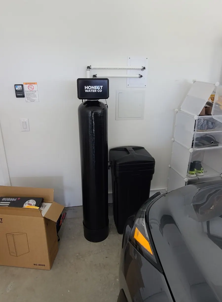 Finished whole-home water softener install with clean plumbing and labeled bypass in a Hall County garage