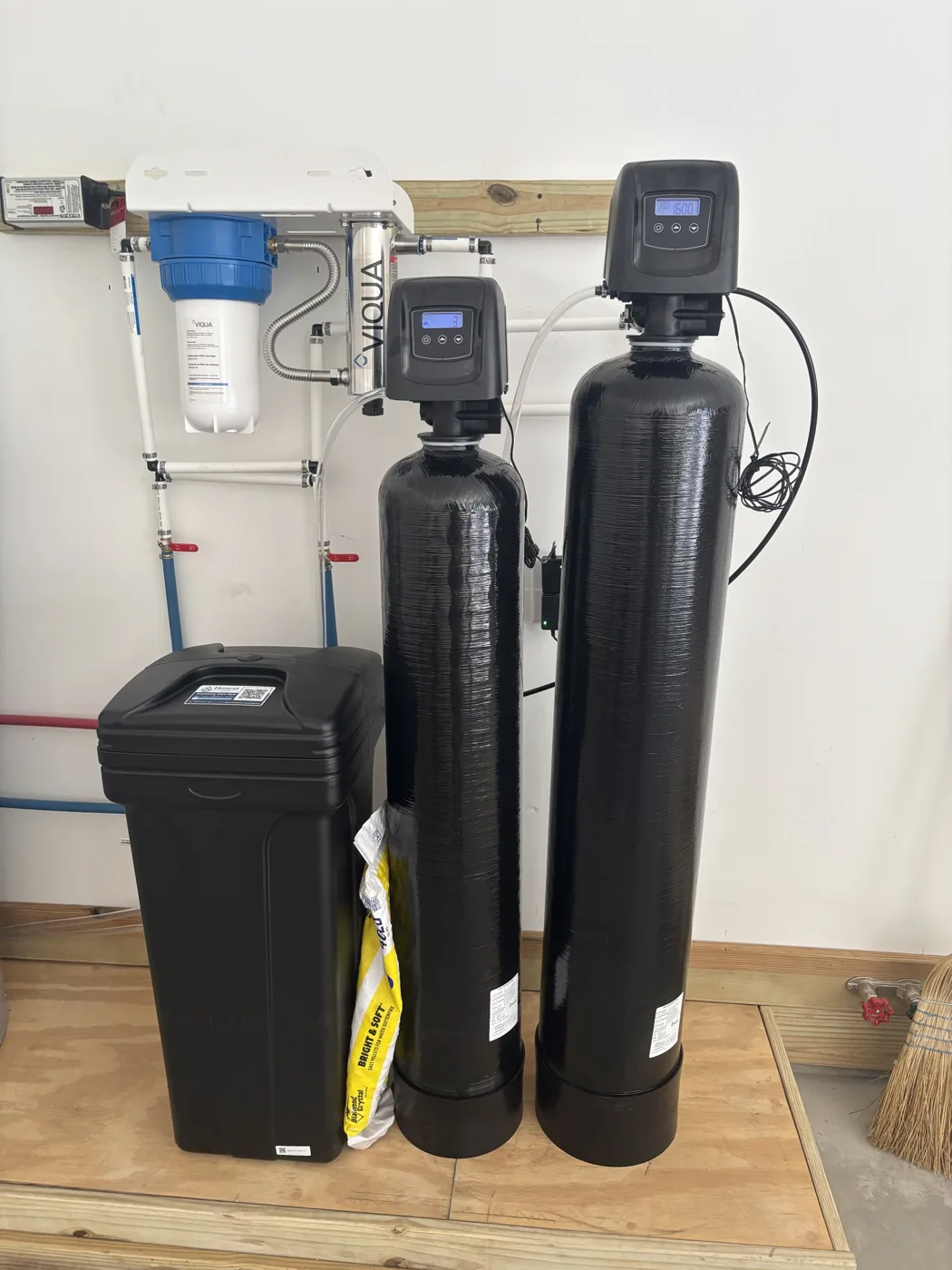 Installed dual-tank whole-home treatment system with a wall-mounted UV unit