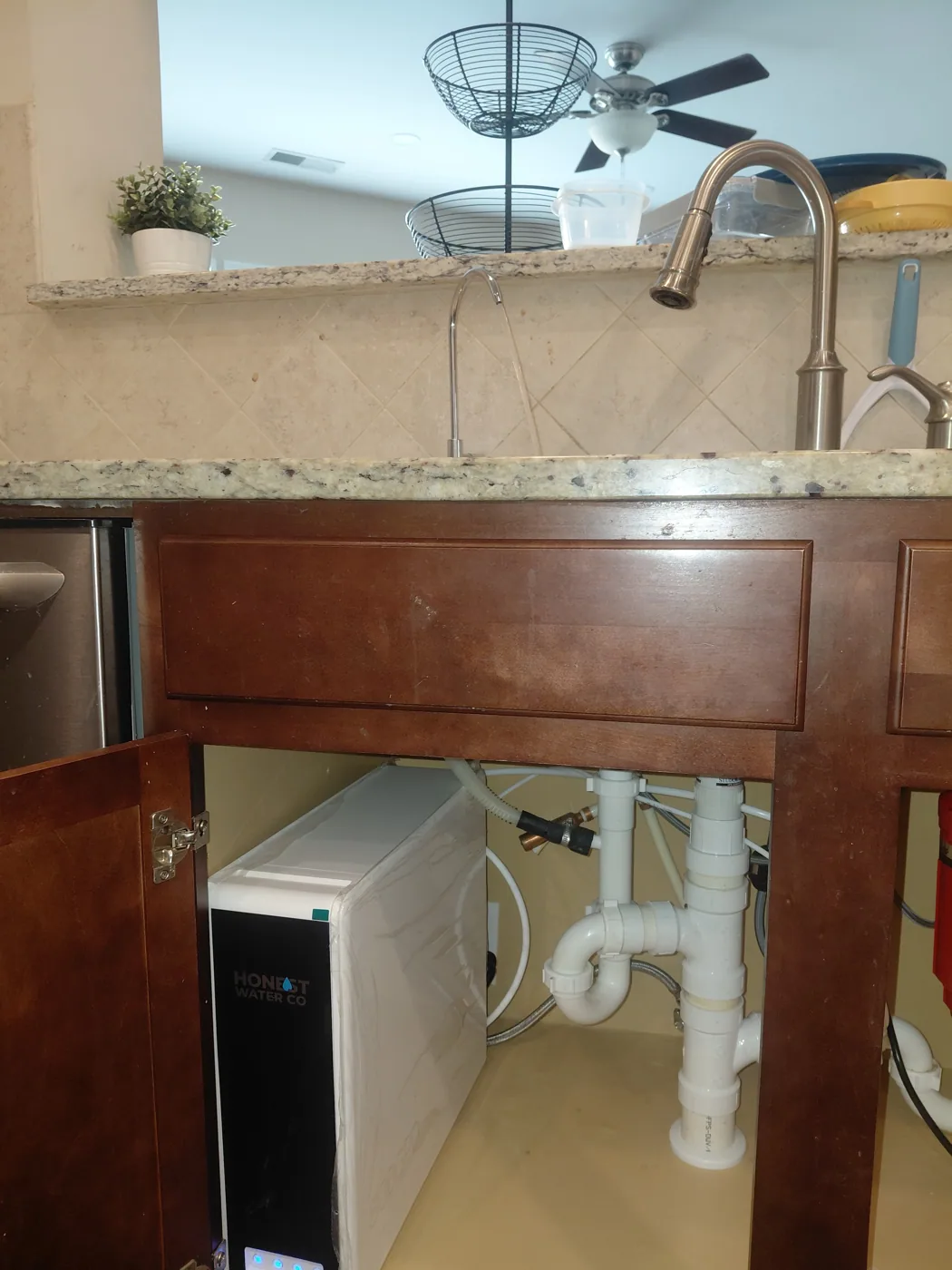 Installed reverse osmosis drinking water faucet at a kitchen sink with the unit in the cabinet below