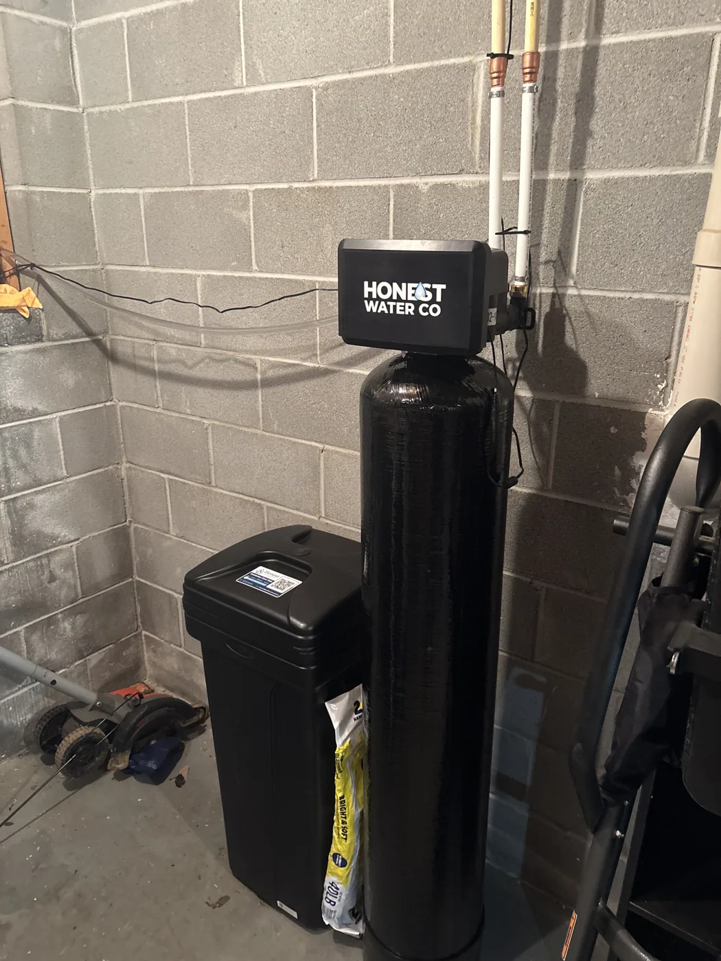 Installed whole-home softening and filtration tanks with brine tank in a utility space